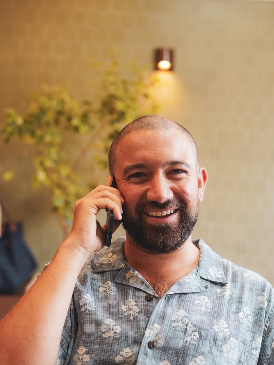 Parker Fritts smiling during a phone call in a sunlit room.